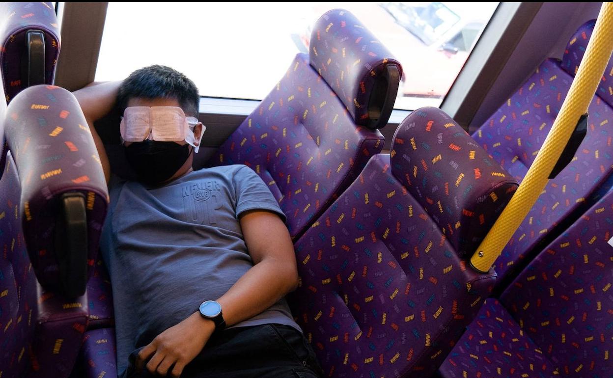Un viajero descansa en el autobús del sueño de Hong Kong.