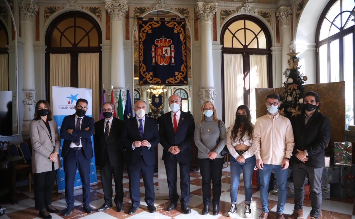 El alcalde de Málaga, los miembros de La Caixa y participantes en el programa, en el salón de los Espejos. 