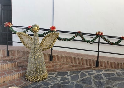 Imagen secundaria 1 - Varios de los adornos navideños y el grupo de mujeres que los ha confeccionado, junto al árbol de la plaza. 