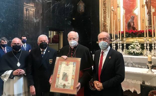 Imagen principal - Momento de la entrega de la distinción a monseñor Amigo Vallejo en la capilla del Cristo de la Buena Muerte. Fernández Verni, cardenal Amigo, monseñor Catalá y Francisco de la Torre. Un momento de la intervención del alcalde de Málaga en el homenaje a Carlos Amigo.