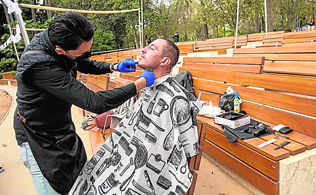 En uno de los bancos del auditorio Eduardo Ocón repasa la barba a Daniel Kaminski, a quien ya había atendido en otra ocasión. 