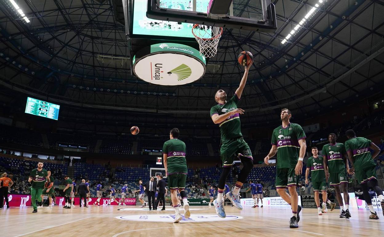 Los jugadores del Unicaja, durante el calentamiento del choque ante el Burgos. 