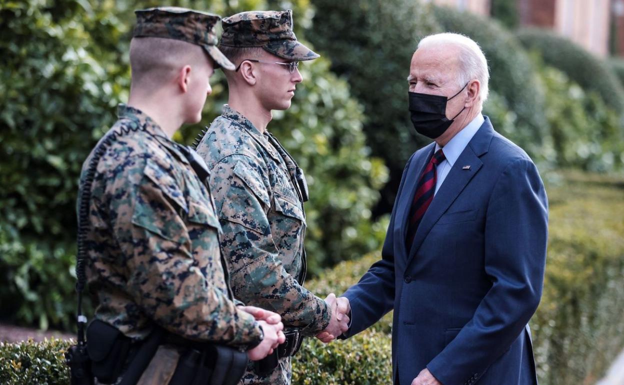 Joe Biden saluda a dos militares. 