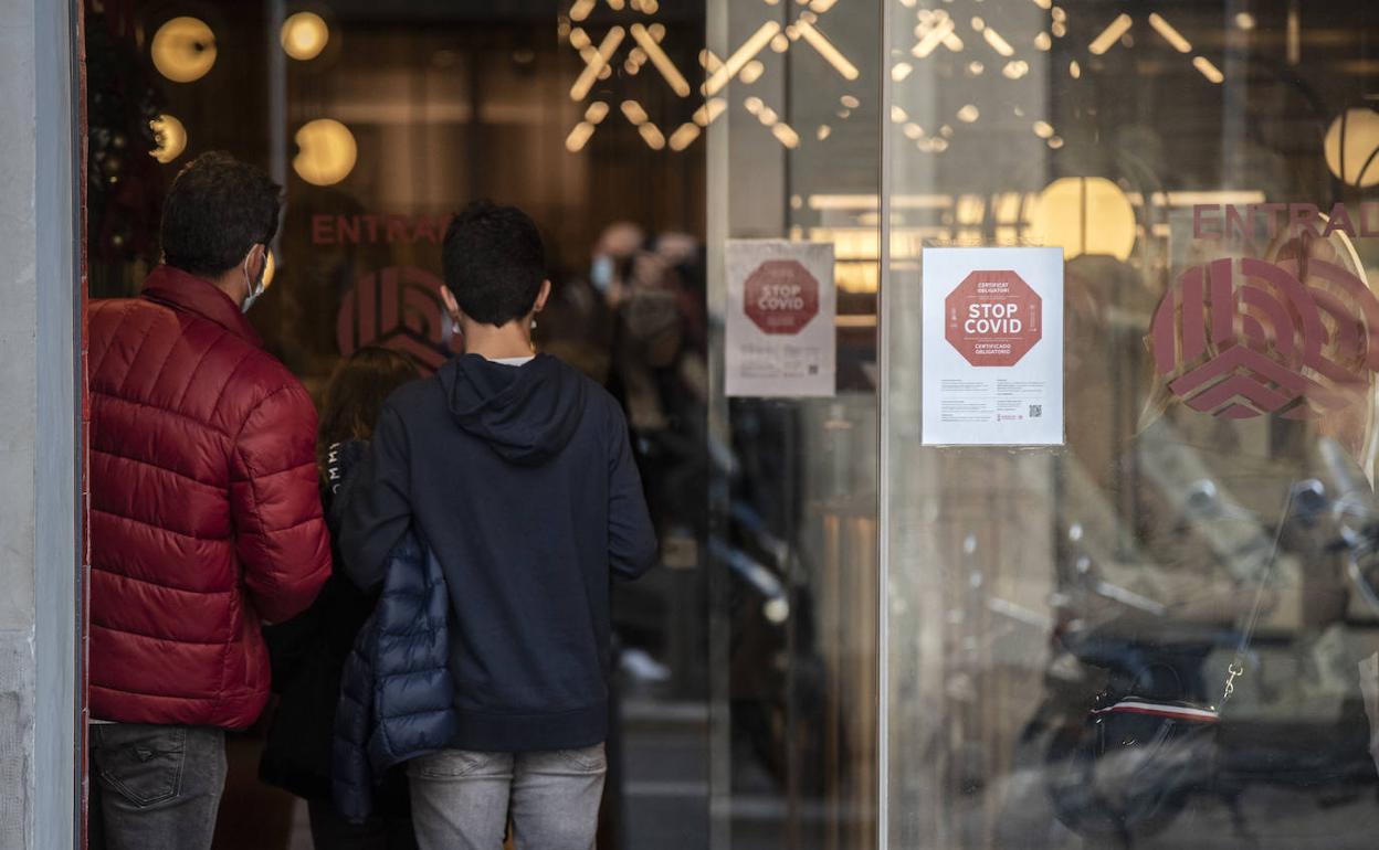 Un local muestra en su puerta la exigencia de mostrar el pasaporte covid. 