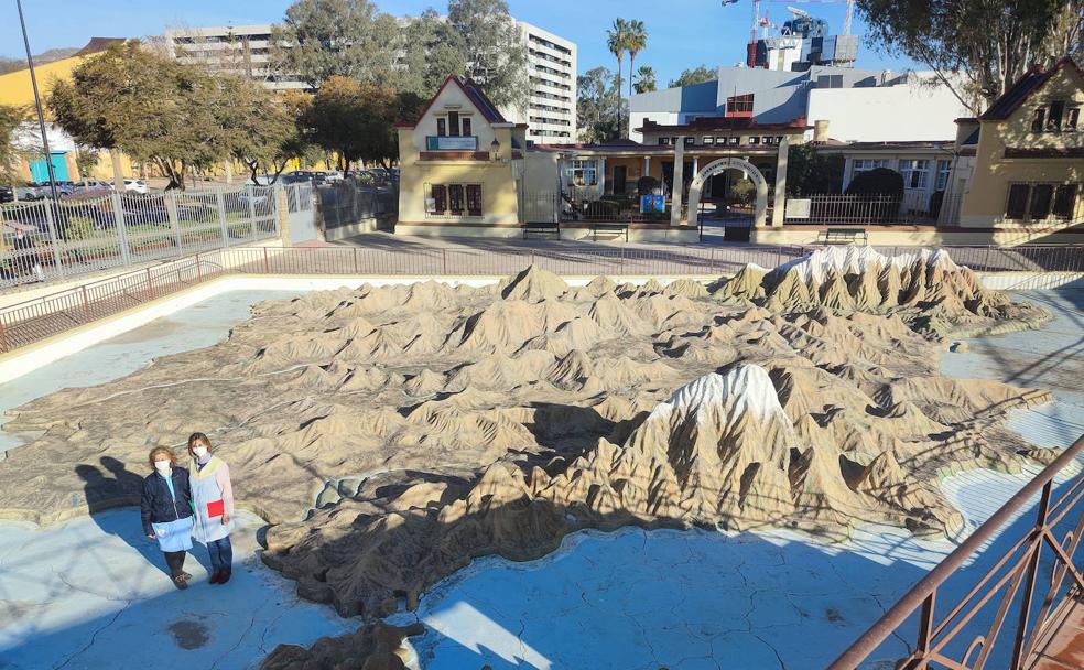 La conserje del centro, María Ruiz, y la directora, Isabel González, posan delante del mapa ubicado en la entrada del colegio. 