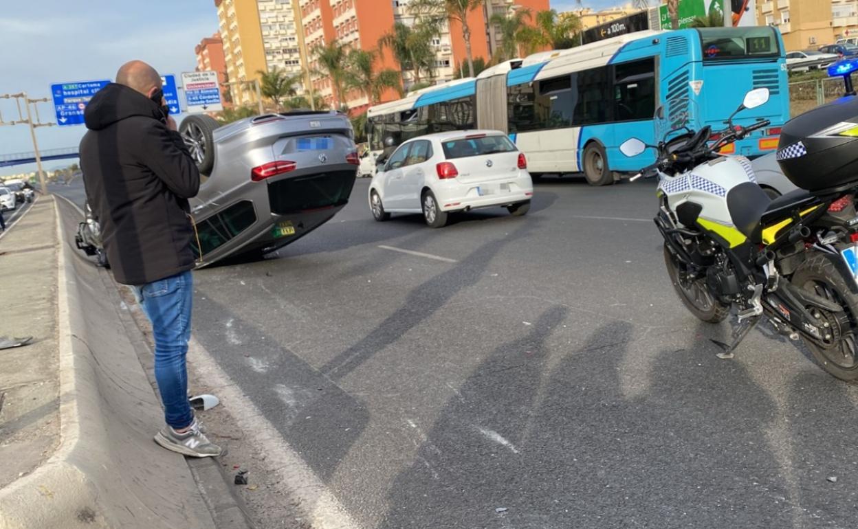 Vuelca un vehículo y otro se da a la fuga al colisionar frente a la Comisaría Provincial de Málaga