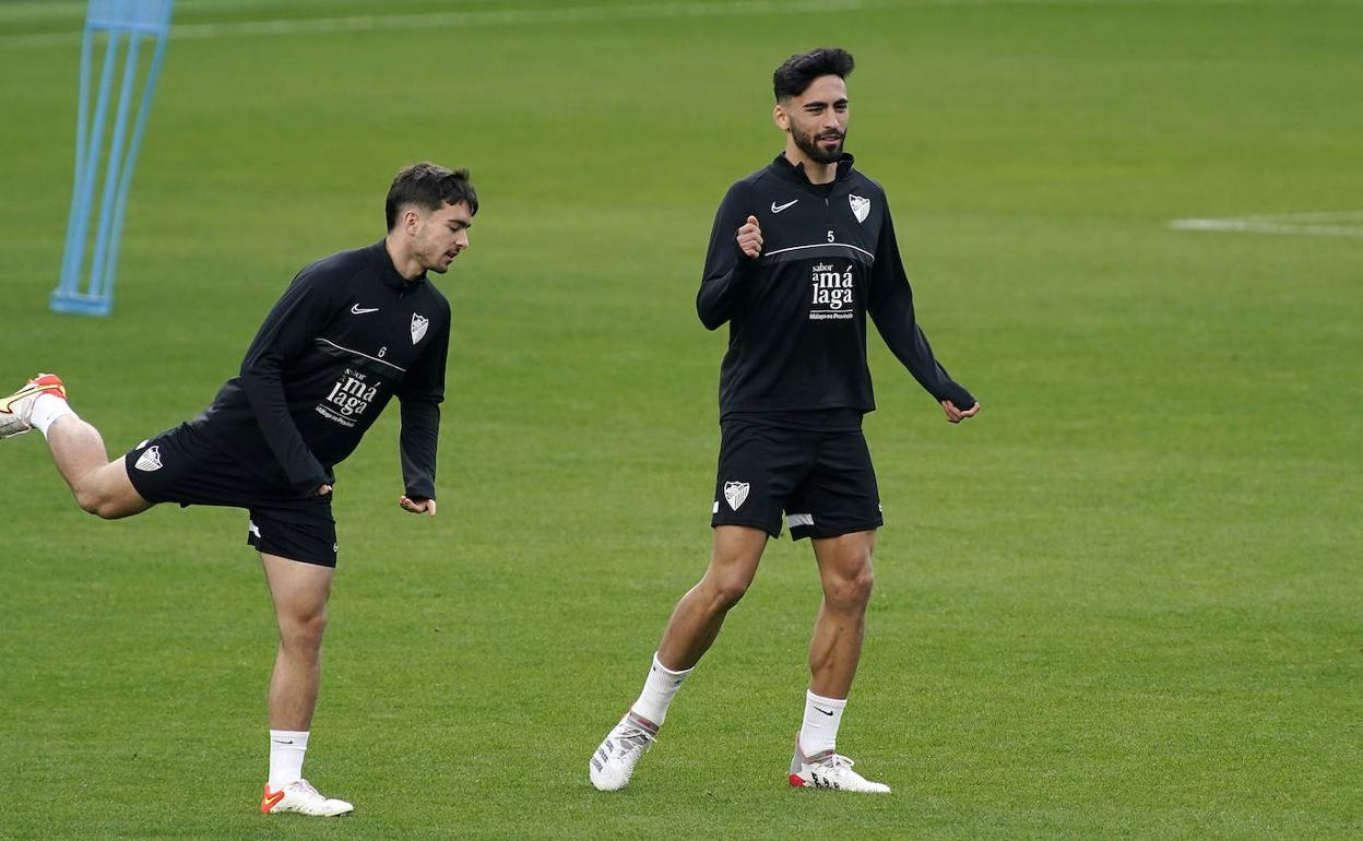 Juande (derecha), durante el entrenamiento del Málaga de este viernes en La Rosaleda.