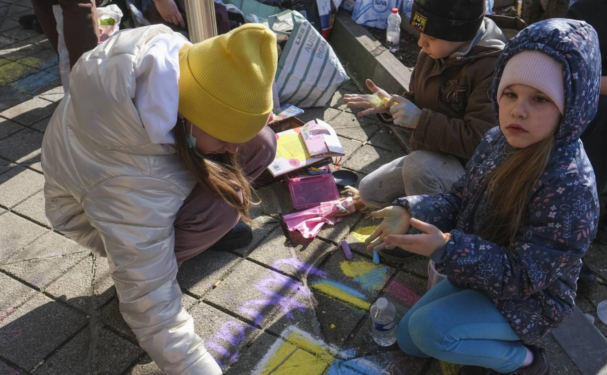 Varios niños pintan la bandera ucraniana en solidaridad con los afectados por la invasión rusa. 