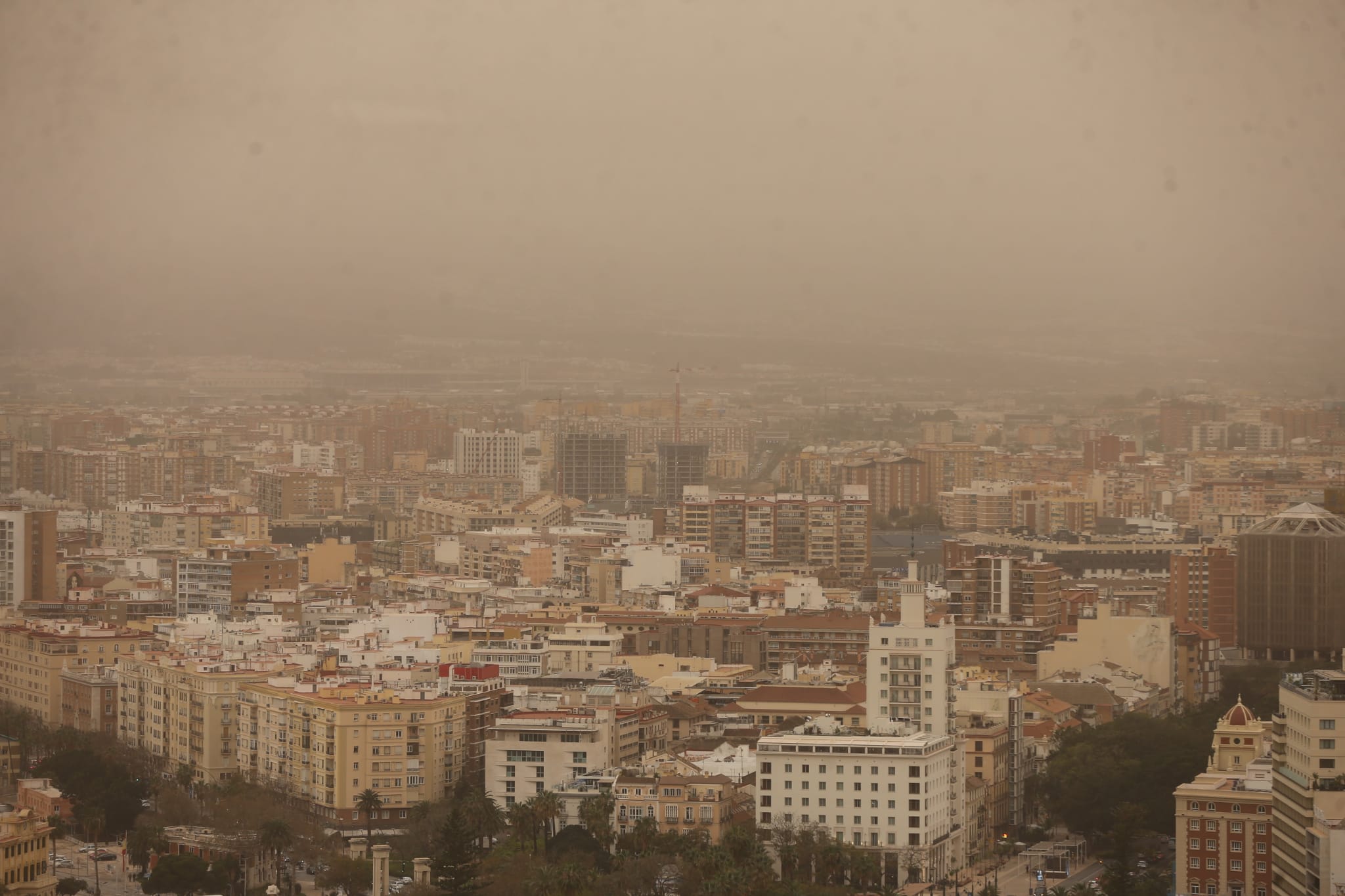 La intrusión de una gran masa en suspensión está dejando las calles y los coches cubiertos de polvo rojo, el mismo color que el cielo.