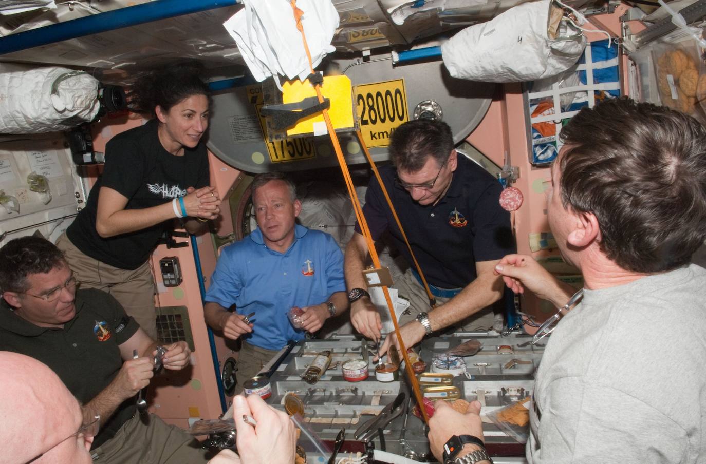 Las tripulaciones de la Expedición 26 de la Estación Espacial Internacional y de la STS-133 comparten mesa en el módulo Unity de la primera.