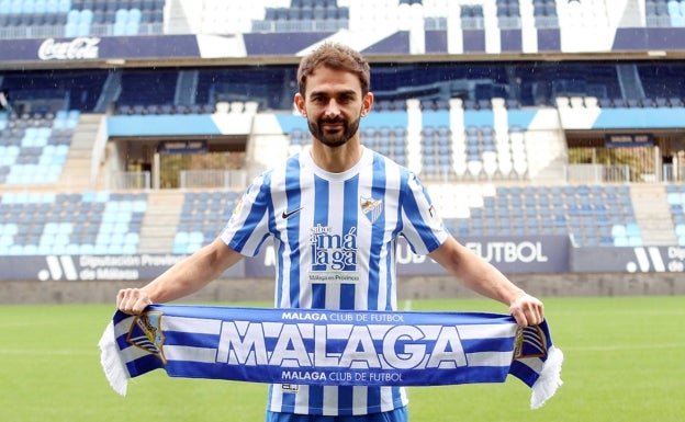 Adrián posa en La Rosaleda con la equipación malaguista y una bufanda. 