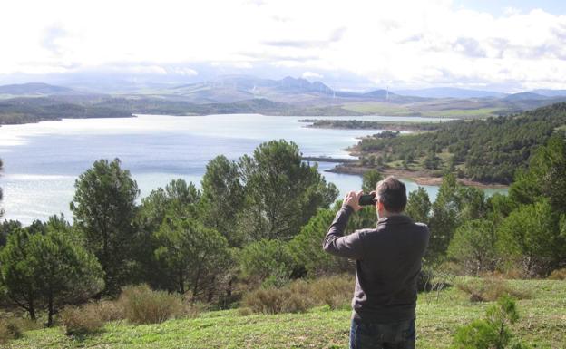 Un turista fotografía con su móvil una panorámica de los embalses.