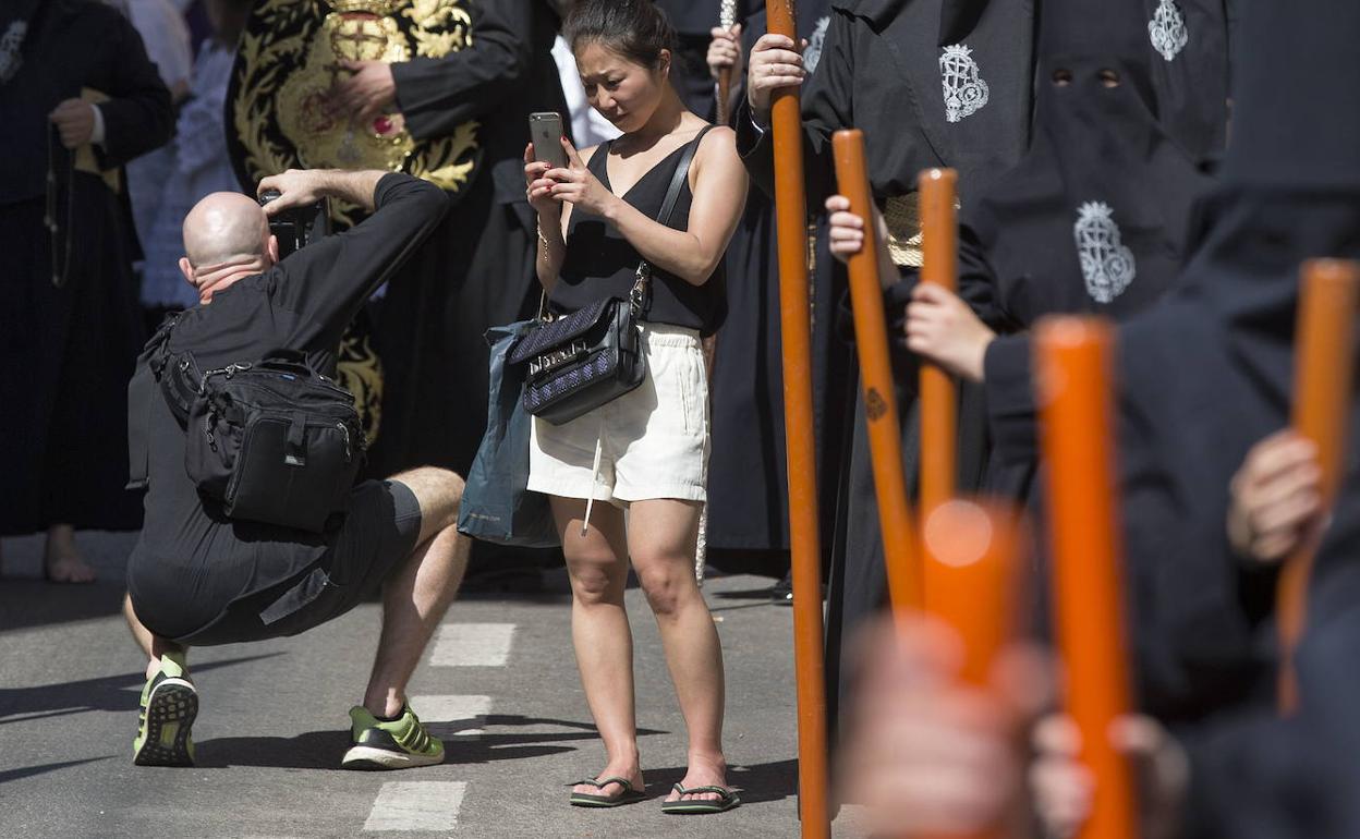 Turistas en manga corta, durante una edición pasada de la Semana Santa en Málaga. 