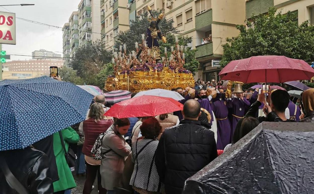 Paraguas abiertos junto al trono del Nazareno del Perdón. 