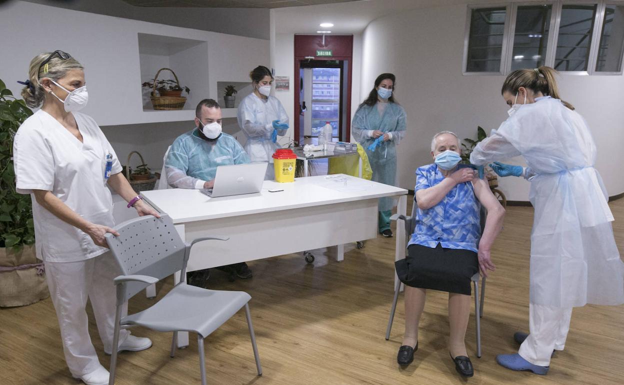 Una residente en un centro de mayores de Asturias recibe la vacuna contra la covid-19.