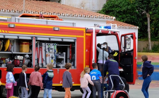 Imagen principal - Tres imágenes de la exhibición de los bomberos este martes en el CEIP Nuestra Señora de la Candelaria de Benagalbón. 