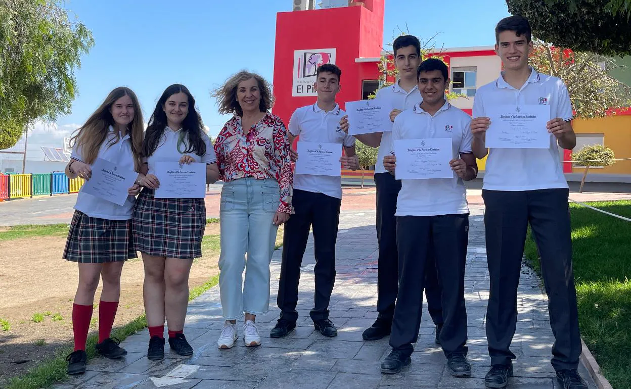 Los alumnos premiados posan con sus diplomas junto a la directora del centro, María José Salom. 