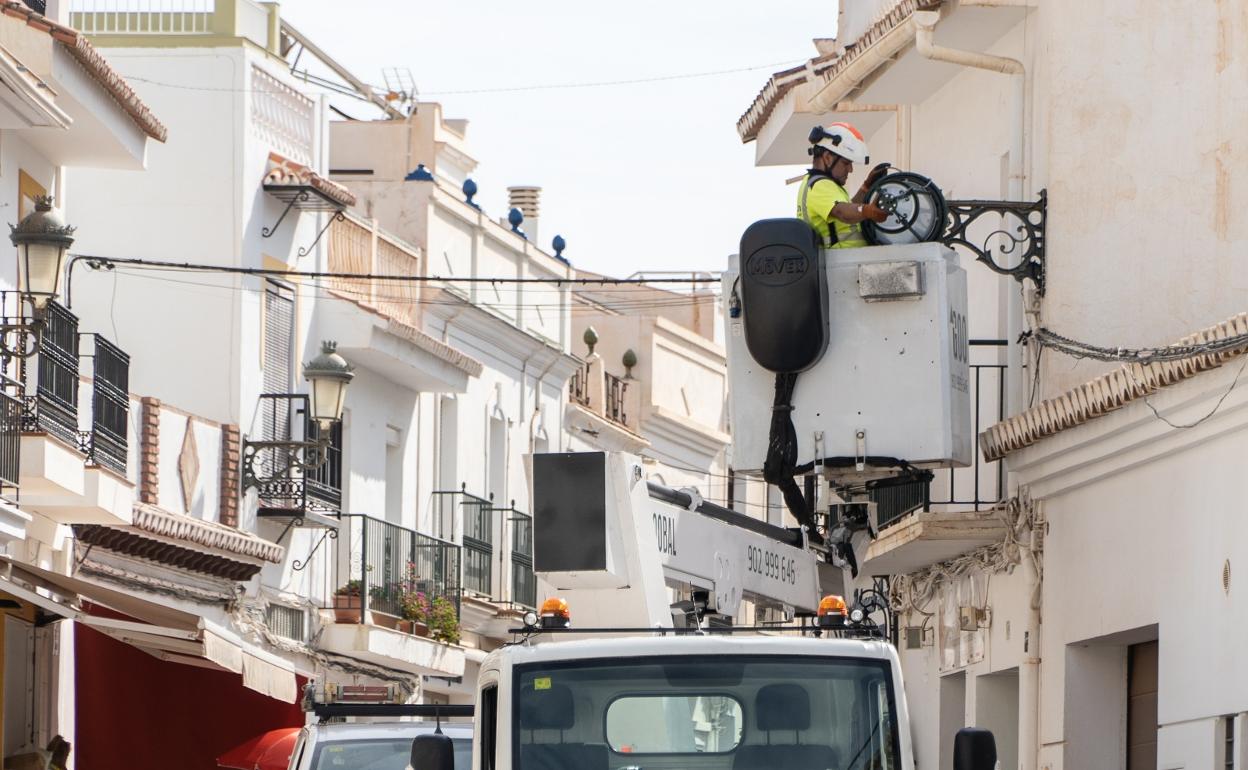 Trabajos de instalación de las nuevas luminarias en una de las calles del centro de Nerja. 