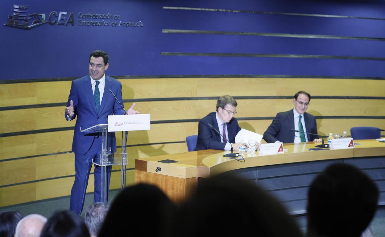 Juanma Moreno se dirige al auditorio en presencia de Alberto Núñez Feijóo y el presidente de la CEA, Javier González de Lara.