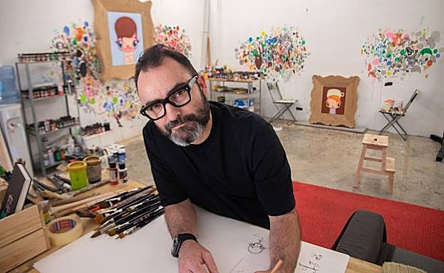 Javier Calleja en su estudio con algunas de las obras que se exponen en París de fondo. 