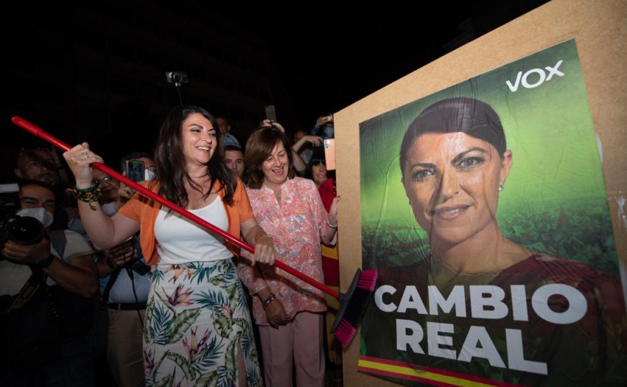 Macarena Olona fijando un cartel electoral con su rostro y el lema de Vox para las elecciones del 19J. 