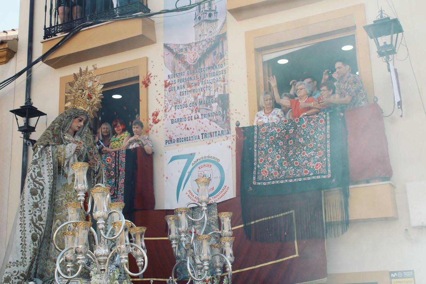 Detalles de la procesión de la Virgen de la Trinidad por las calles de su barrio. 