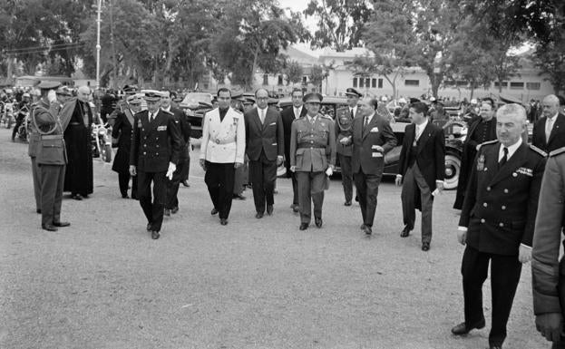 28 de abril, 1961. El general Franco inaugura oficialmente las instalaciones de Martiricos. El original fotográfico se encuentra un tanto deteriorado, aunque no lo suficiente para restar valor al documento histórico. Imagen representativa del tono general del reportaje, es también un retrato de época. Significar la ausencia de mujeres en el grupo y la distancia que separa a Herrera Oria del resto de autoridades que flanquean a Franco. En ninguna de las fotografías que integran este reportaje vuelve a aparecer el futuro cardenal, ni siquiera en aquellas que muestran la bendición de las instalaciones, oficiada por el obispo coadjutor Benavent Escuín.