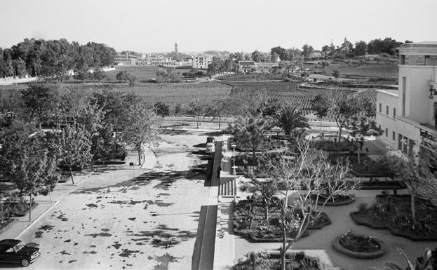 Abril, 1959. En primer término, jardines de acceso a la Escuela de Formación Profesional Francisco Franco. Al fondo, a la izquierda, se aprecian las instalaciones del Instituto Masculino, todavía en obras. La Escuela impartía docencia desde el curso académico 1947/48.