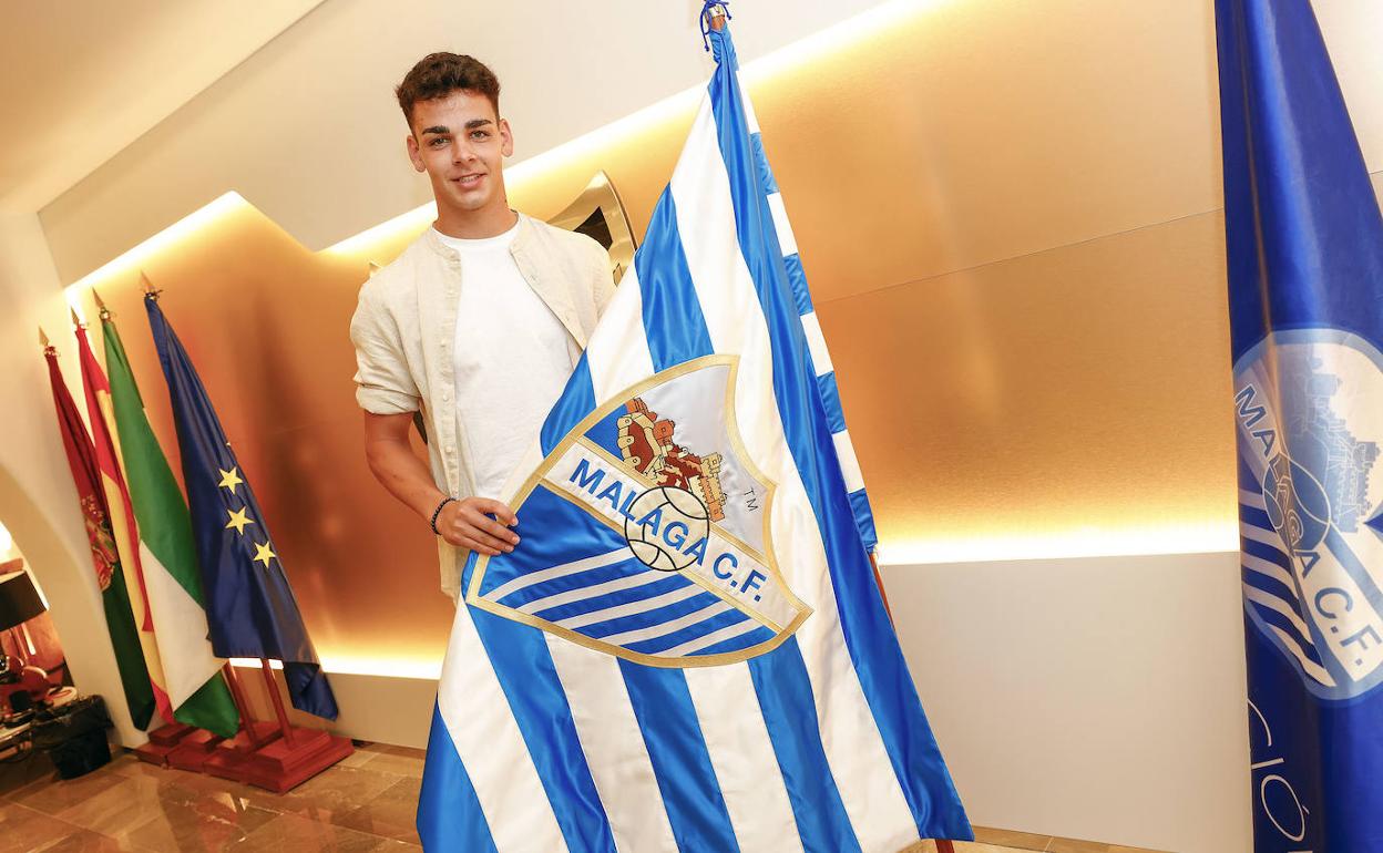 Andrés Caro posa con la bandera del Málaga tras ampliar su contrato. . 