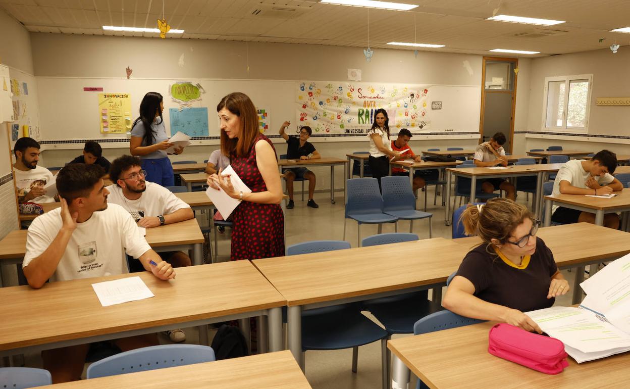 Las profesoras Myriam Delgado, Ana Osorio y María José Barba reparten los exámenes a los alumnos. 