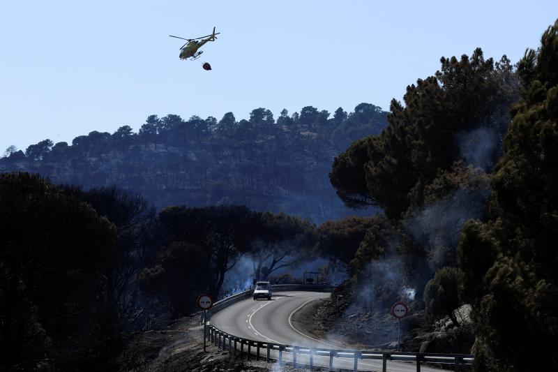 Un helicóptero refresca una de las zonas calcinadas en Cebreros. 