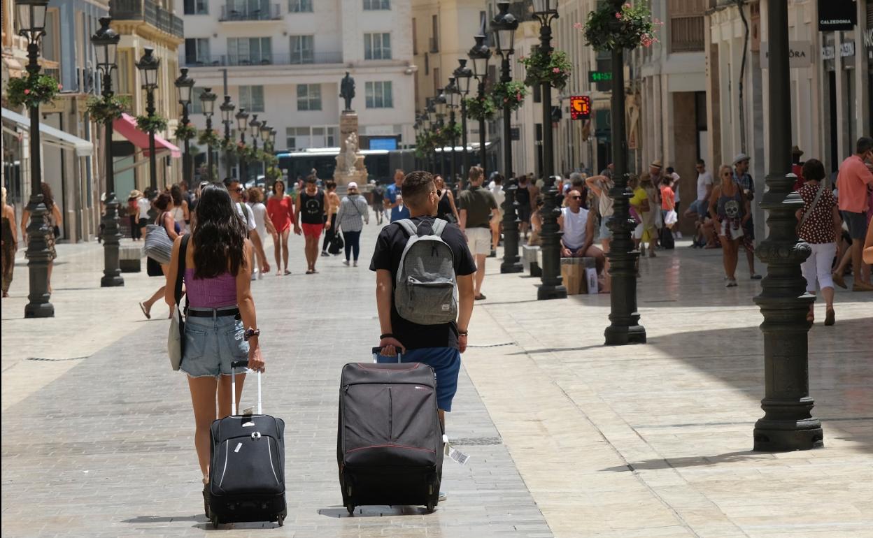Turistas se dirigen a su alojamiento, recorriendo el Centro de la ciudad. 