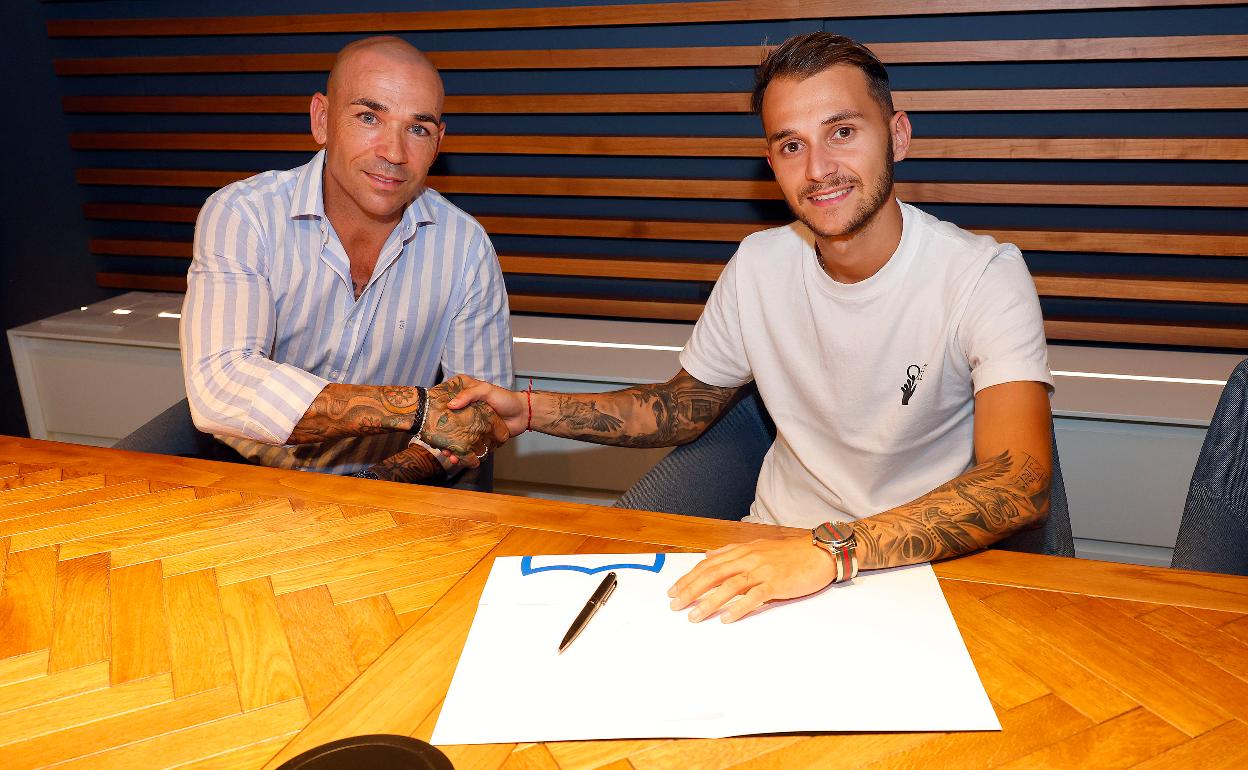 El director deportivo del Málaga, Manolo Gaspar, y Fran Villalba, nuevo jugador del equipo, se dan la mano tras firmar el contrato.