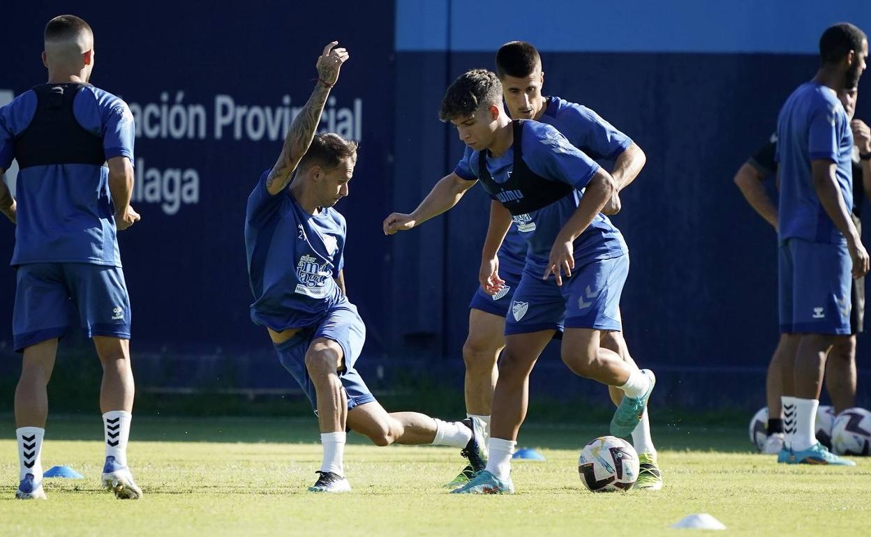 Fran Villalba, en escorzo, trata de frenar a Haitam en presencia de Bustinza. 