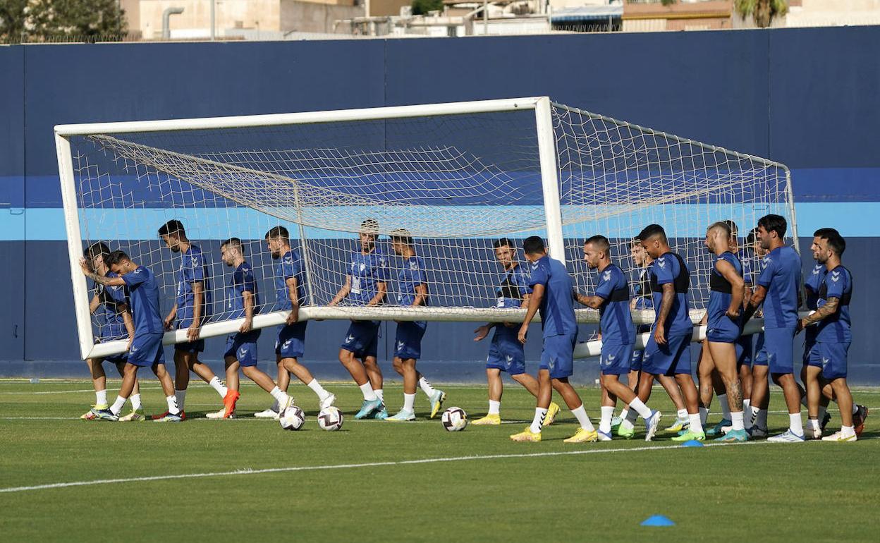 Jugadores del Málaga portan una portería para un ejercicio en un entrenamiento días atrás en el Anexo de La Rosaleda.