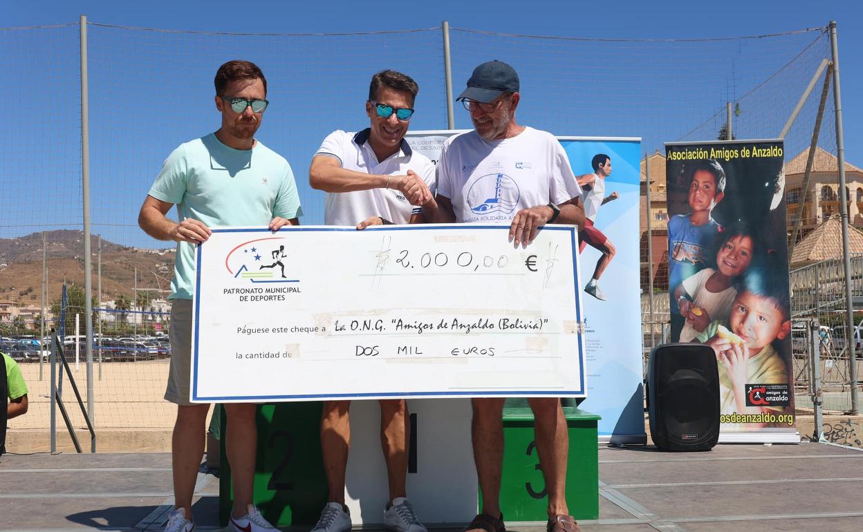 Entrega del cheque con la recaudación solidaria en la prueba disputada este domingo en Torrox. 