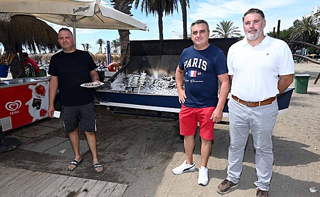 El presidente de la Cofradía de Pescadores, Manuel Haro, y el asesor de Playas, Francisco Gaona, (a la derecha) junto a una barca de espetos y un espetero local en la presentación de la moraga popular. 