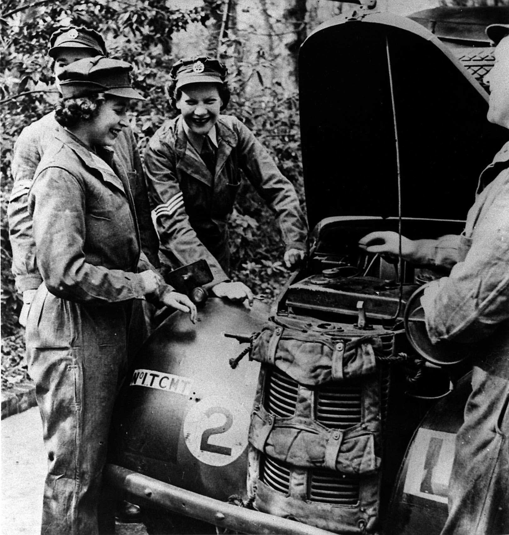 Isabel II, a la izquierda, recibe instrucción sobre mantenimiento de vehículos, en una imagen de enero de 1945. Se cree que es la última foto de la soberana vistiendo pantalones hasta enero de 2003, cuando salió del hospital Rey Eduardo VII, donde fue operada de la rodilla.