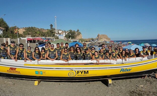 Foto de grupo con numerosos remeros del CDR La Araña, en el varadero de la playa y junto a una jábega con sus patrocinadores. 