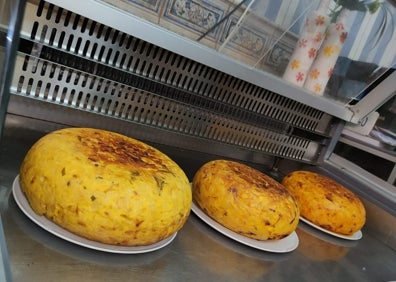 Imagen secundaria 1 - Arriba Ángela Abdukla y Evedina Rivera, con otra de las tortillas gigantes que elaboran a diario y debajo varia de sus trabajos. 