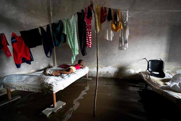 Una niña yace tumbada en su habitación, completamente inundada, en la localidad de Batabano, en la región occidental de la isla, una de las más afectadas por el paso de Ian.