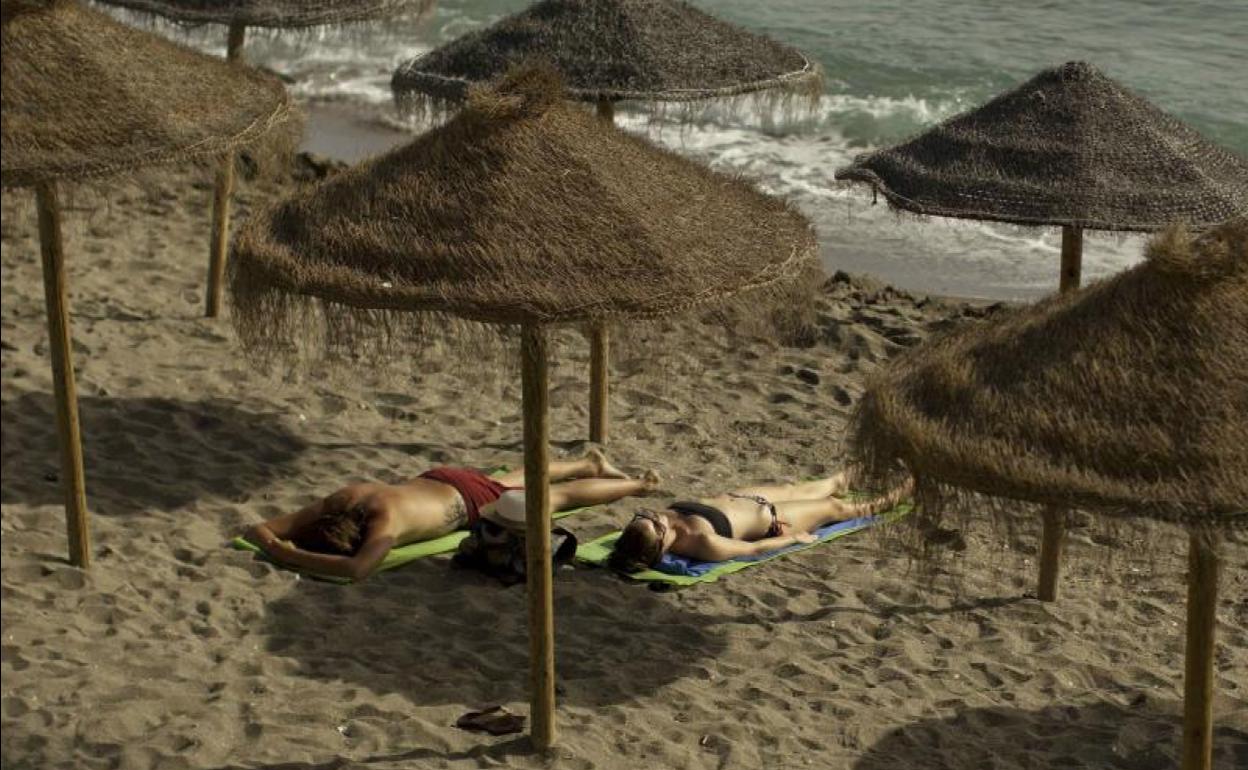 Turistas toman el sol en Marbella en pleno otoño. 