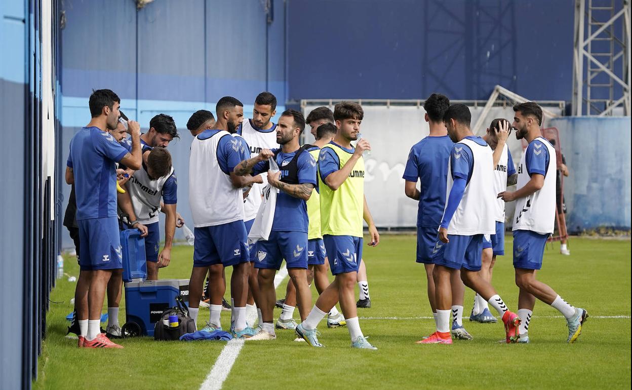 Jugadores del Málaga toman agua durante una pausa del entrenamiento de este miércoles en el Anexo de La Rosaleda. 