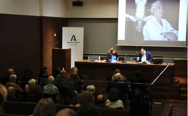 La directora del Museo de Málaga, María Morente, junto a Pedro Luis Gómez, durante la conferencia. Al fondo, una imagen de Paco Hernández. 