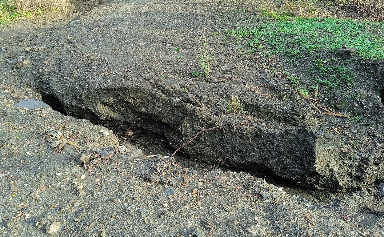 Imagen de uno de los socavones en el carril de acceso a la zona de Santillán. 