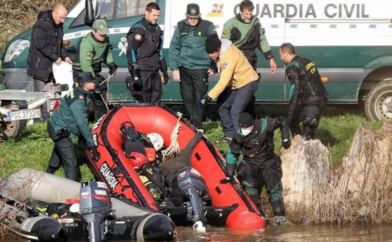 Los agentes sacan a la orilla la barca con el cuerpo de una de las víctimas.