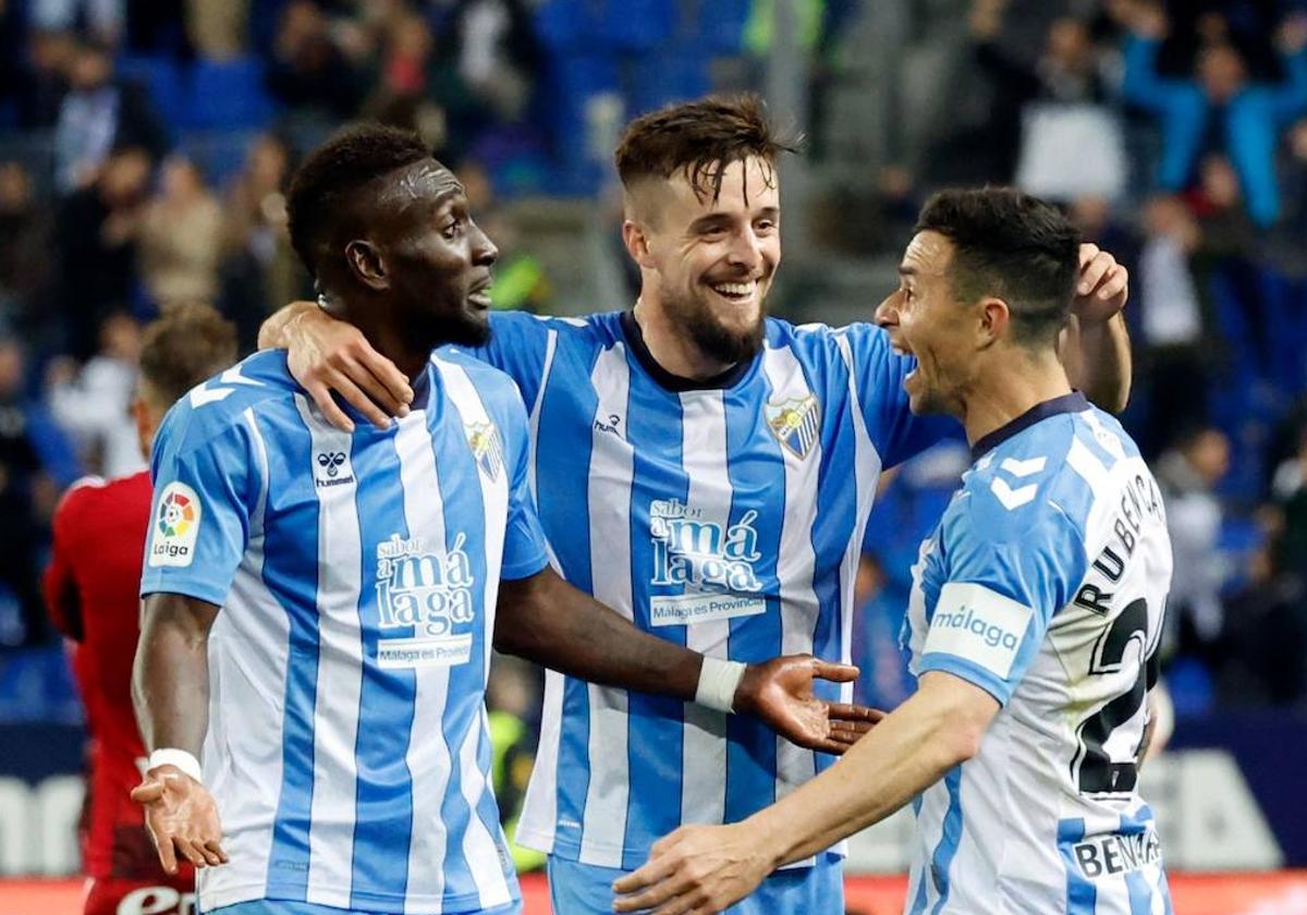 Genaro, en el centro, abraza a Lago Junior y Rubén Castro en el pasado Málaga-Zaragoza.