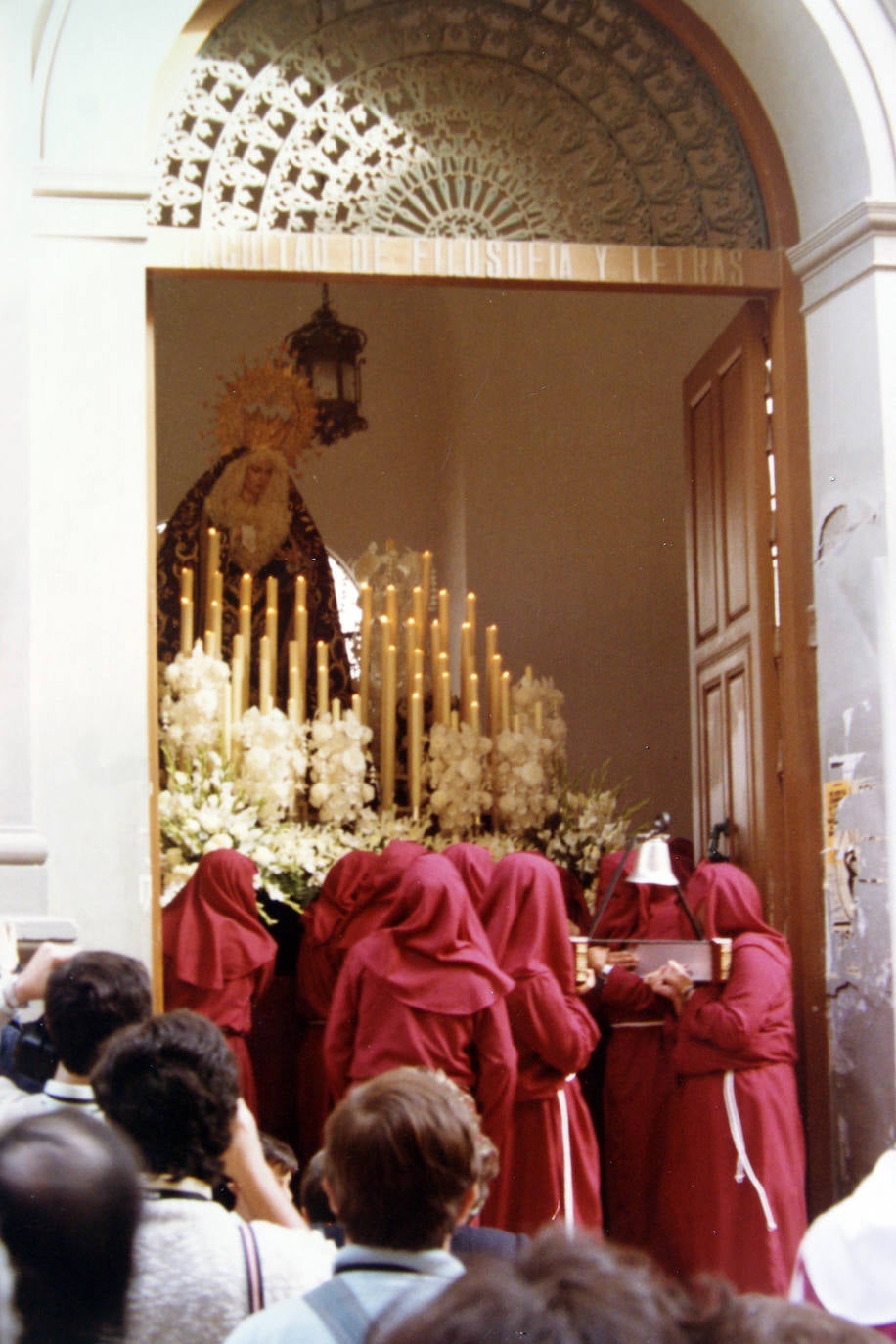 En 1985 procesionó por primera vez la antigua Virgen de la Salud. Curiosamente, y como se observa en la fotografía, lo hizo desde el antiguo Colegio de San Agustín, que entonces era la sede de la Facultad de Filosofía y Letras, ya que las monjas de la abadía de Santa Ana del Císter, aconsejadas por la Orden de Caballeros del Císter, no dieron su consentimiento al establecimiento canónico de la corporación en sus dependencias. La primera marcha que se le tocó a la Dolorosa fue 'Virgen de las Aguas', que todavía se le interpreta cada Domingo de Ramos.