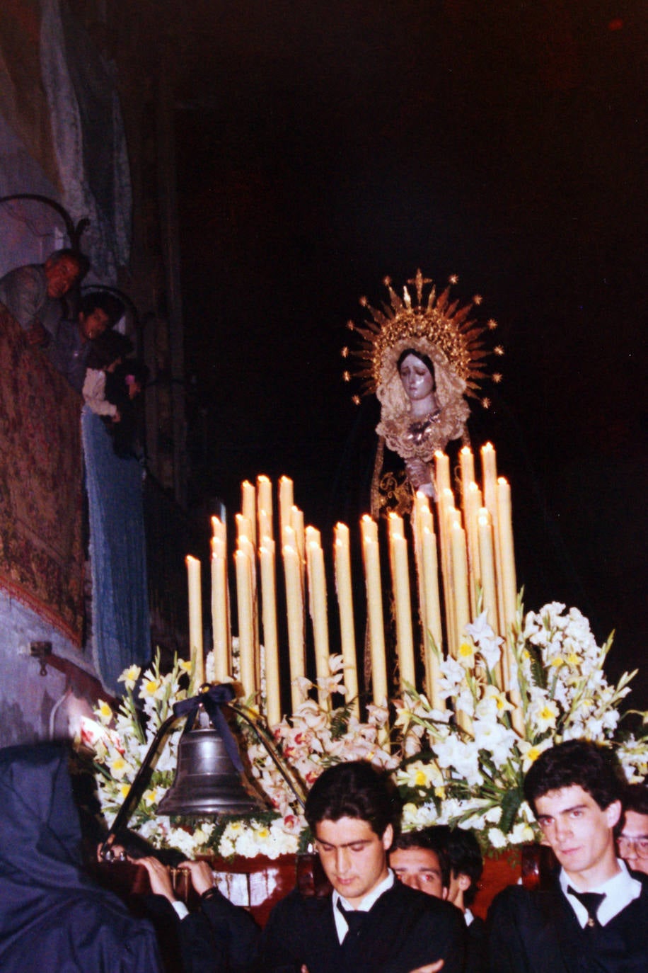 La Virgen de los Dolores del Puente pasa por ser una de las imágenes más meritorias de la Semana Santa de Málaga, atribuida a Pedro Asensio de la Cerda, del siglo XVIII. En la, foto, la Dolorosa por las calles de El Perchel en una de sus primeras salidas, tras la reorganización de la cofradía. En concreto, se corresponde con el año 1983.