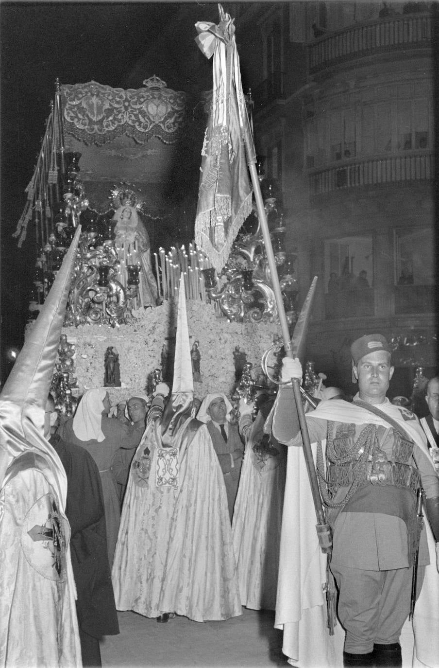 La Virgen de la Trinidad estrenó en 1953 algunas partes del trono de Pedro Pérez Hidalgo, caso de los arbotantes. En el cajillo de flores figuraban esculturas en miniatura. Aunque la auditoría de este trono siempre fue atribuida al referido Pérez Hidalgo, sus verdaderos autores fueron, casi en su totalidad, los tallistas Victoriano Pérez Aranda y Rafael Reigal Guerrero. La confusión viene de la firma de un primer contrato entre la cofradía y Pérez Hidalgo en 1952. Fue a partir de 1957 cuando, tras la redacción de un nuevo contrato con Reigal, los artesanos referidos realizaron el grueso del trono y le dieron su configuración final.